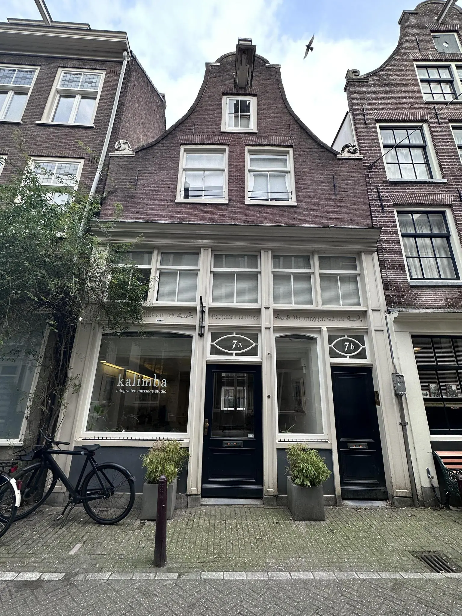 Voorgevel van een karakteristiek Amsterdams grachtenpand aan de Eerste Lindendwarsstraat met het massagebedrijf Kalimba op de begane grond.